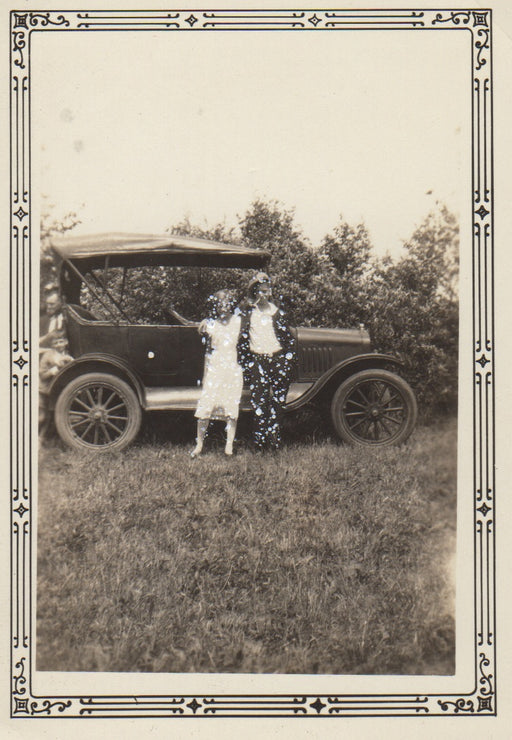 Girl and boy in front of a car