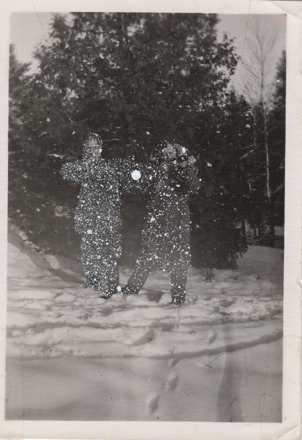 Two men posing with rifles in a snowy field