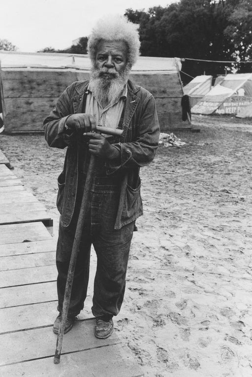 Untitled [Old man in front of tent city]