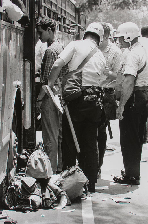 Untitled [Three cops frisking a man in front of a bus]