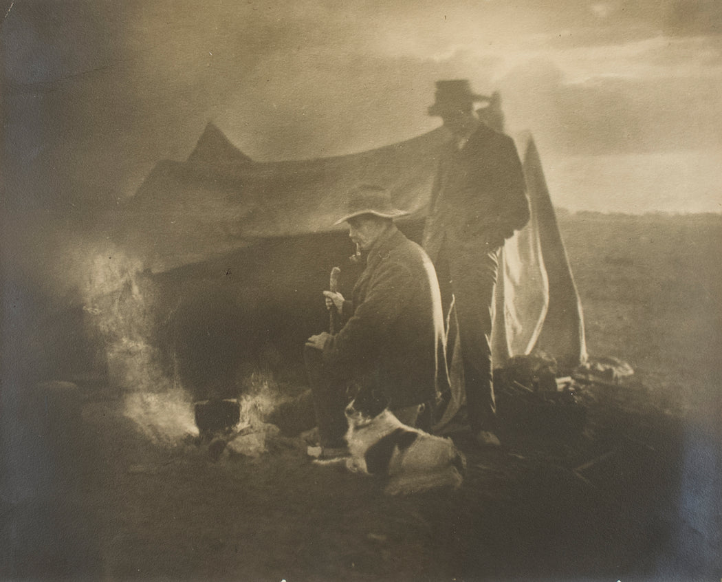 Untitled [Two men and a dog at a campfire]