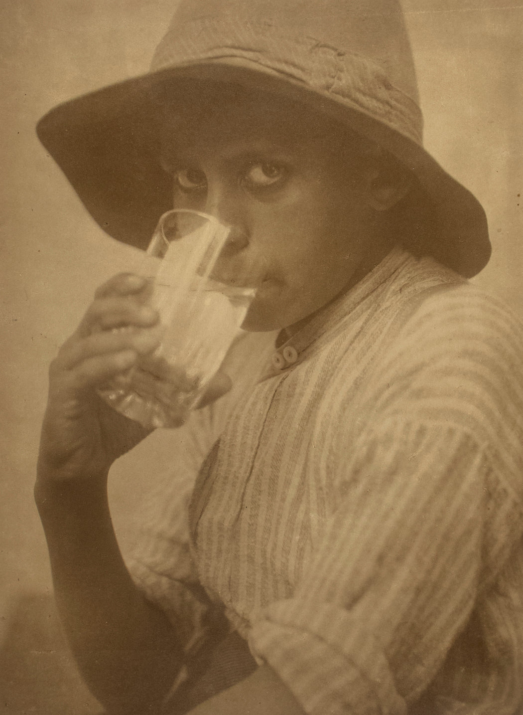 Untitled [Young boy drinking from a glass]