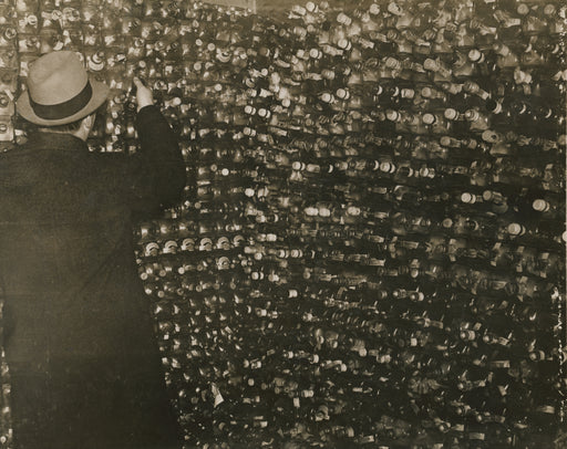 Untitled [Federal agent inspecting confiscated bottles]