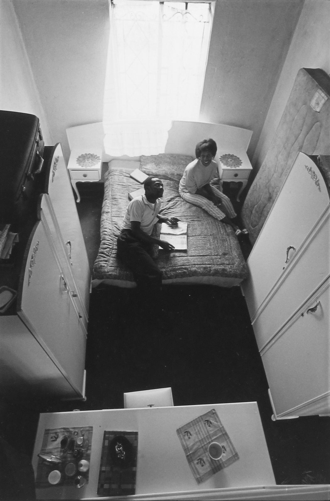 Untitled [Aerial view of couple sitting in bedroom]
